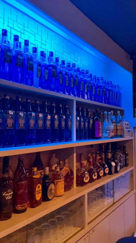 青色が輝くボトルが並ぶ店内