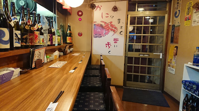 日本酒や焼酎の一升瓶が並ぶカウンター